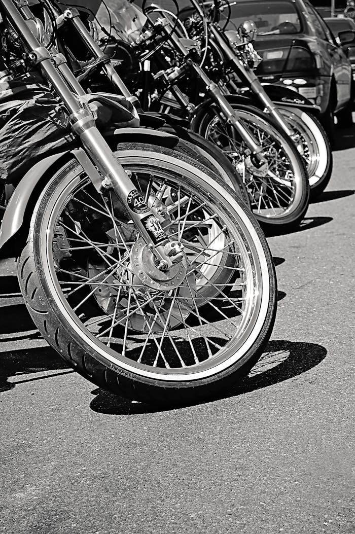 Black and white photo of parked motorcycles in Brooklyn, NY, highlighting wheels and chrome.