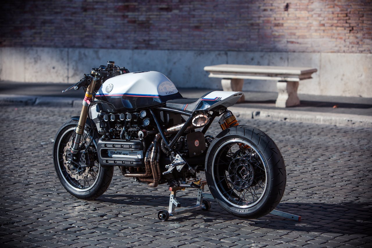 Classic vintage cafe racer motorcycle parked on cobblestone street, Rome, Italy.
